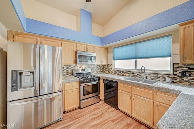 kitchen with light brown cabinetry, tasteful backsplash, stainless steel appliances, vaulted ceiling, and sink