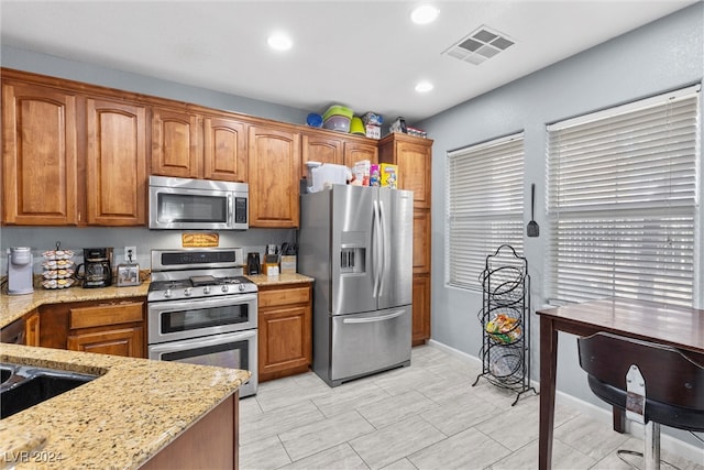 kitchen with light stone countertops and stainless steel appliances