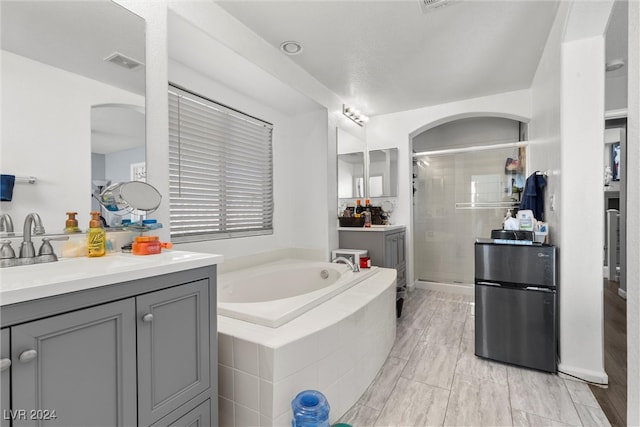 bathroom featuring separate shower and tub, hardwood / wood-style floors, and vanity