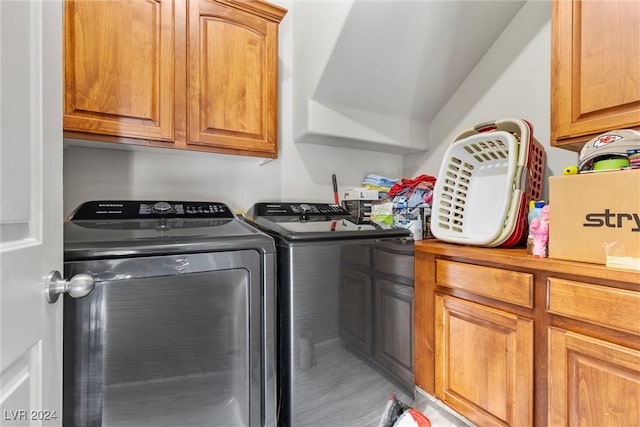 clothes washing area with cabinets and independent washer and dryer