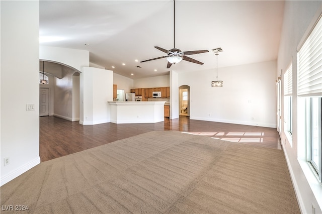 unfurnished living room with dark hardwood / wood-style floors and ceiling fan