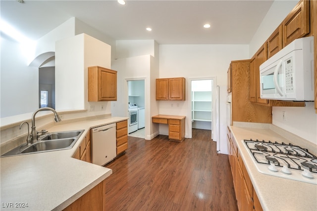 kitchen with dark hardwood / wood-style flooring, white appliances, and sink