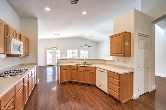 kitchen with white appliances, sink, hanging light fixtures, vaulted ceiling, and dark hardwood / wood-style floors