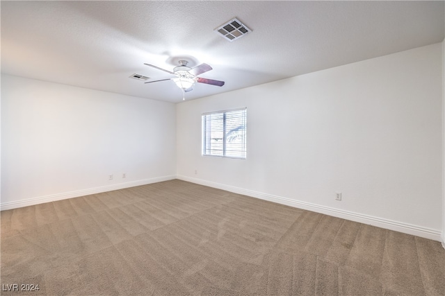 carpeted spare room with ceiling fan and a textured ceiling