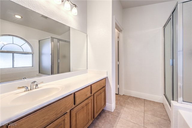 bathroom featuring shower with separate bathtub, vanity, and tile patterned floors