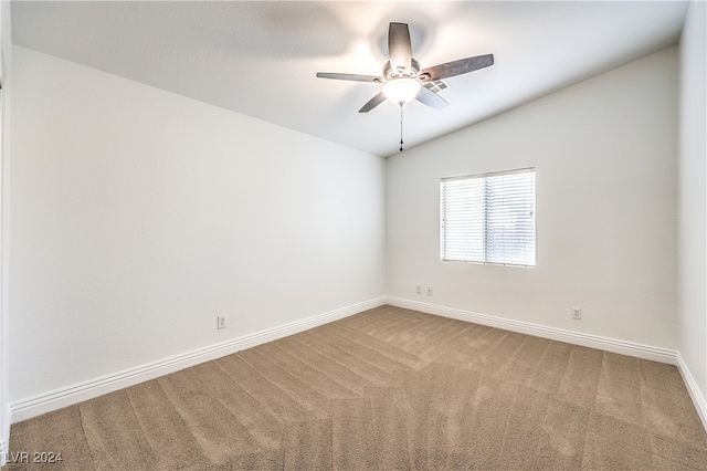 empty room featuring ceiling fan, carpet floors, and vaulted ceiling