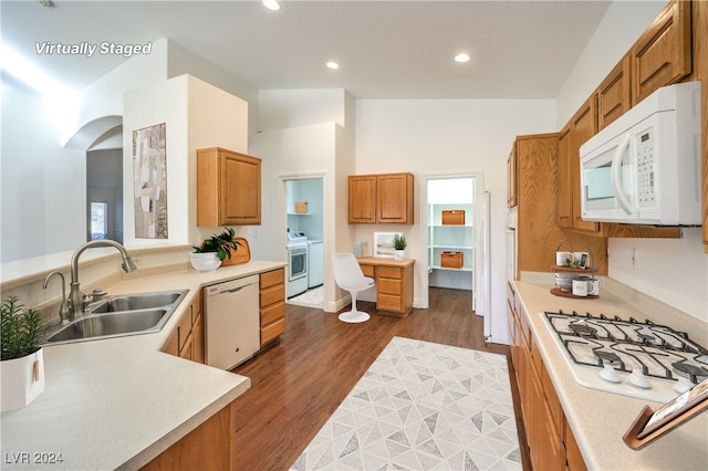 kitchen with vaulted ceiling, sink, dark wood-type flooring, and white appliances