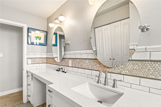 bathroom with tasteful backsplash, vanity, and wood-type flooring