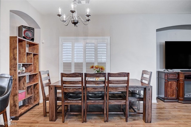 dining area featuring light wood-type flooring and an inviting chandelier