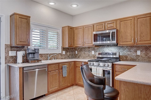 kitchen with light tile patterned floors, backsplash, stainless steel appliances, and sink