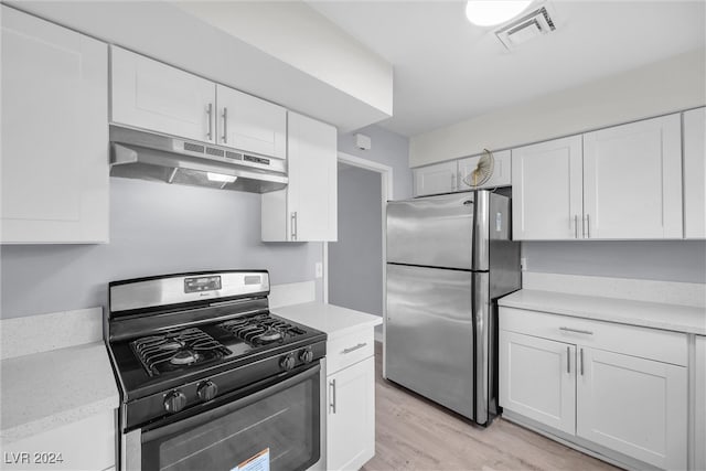 kitchen with white cabinets, light wood-type flooring, and stainless steel appliances