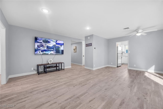 living room with light hardwood / wood-style flooring and ceiling fan