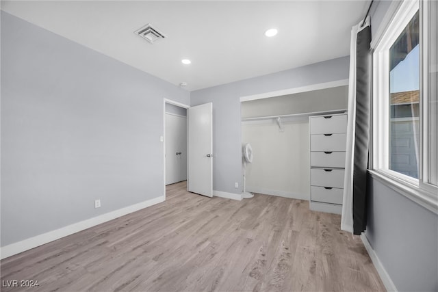 unfurnished bedroom featuring a closet and light hardwood / wood-style flooring