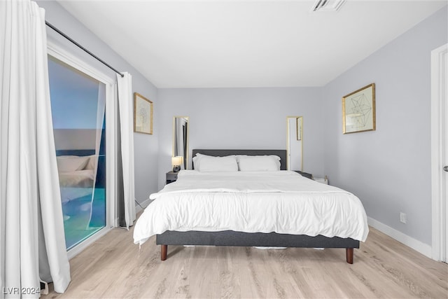 bedroom with light wood-type flooring and access to outside