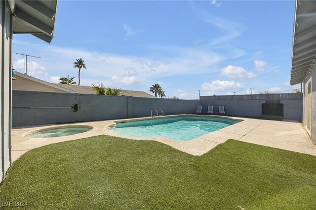 view of swimming pool with a lawn, an in ground hot tub, and a patio