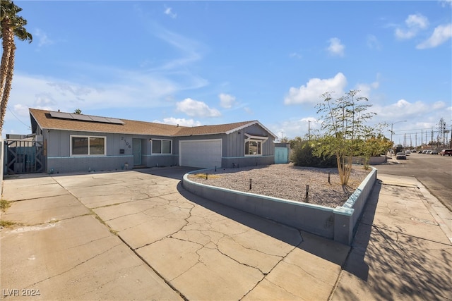 single story home featuring a garage and solar panels