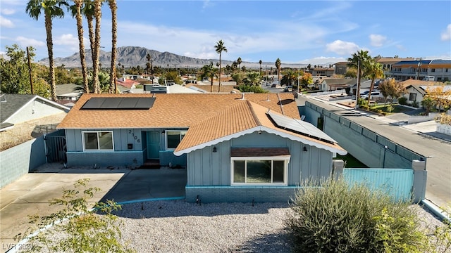 view of front of property featuring a mountain view and solar panels