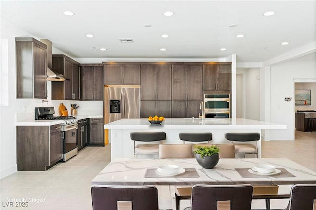 kitchen with a kitchen bar, stainless steel appliances, and a kitchen island with sink