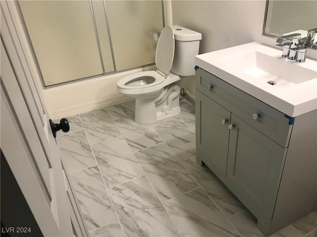 full bathroom featuring vanity, toilet, and bath / shower combo with glass door