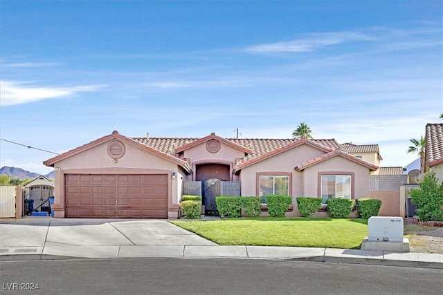 mediterranean / spanish home with a garage and a front lawn