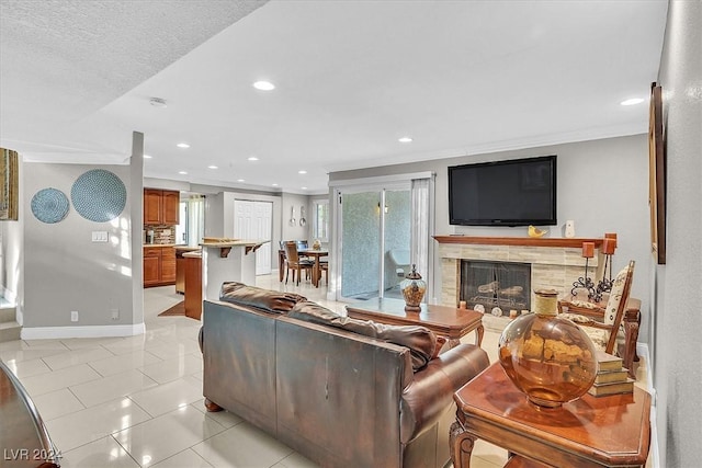 living room featuring a fireplace, light tile patterned floors, a textured ceiling, and ornamental molding