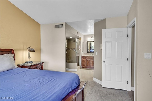 bedroom with carpet floors, sink, and connected bathroom