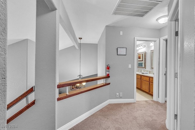 hall featuring vaulted ceiling with beams and light colored carpet