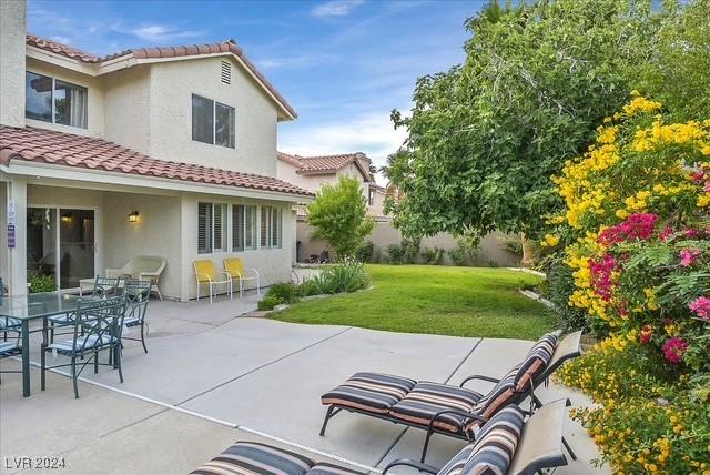 rear view of house with a yard and a patio area