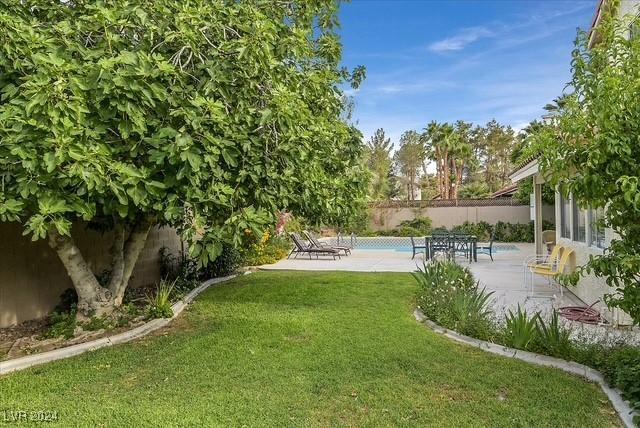 view of yard with a fenced in pool and a patio