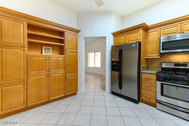 kitchen with tasteful backsplash, light tile patterned floors, stainless steel appliances, and ceiling fan