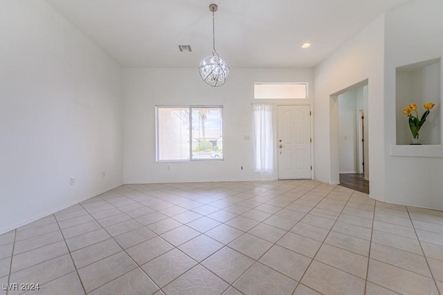 foyer entrance with light tile patterned floors and an inviting chandelier