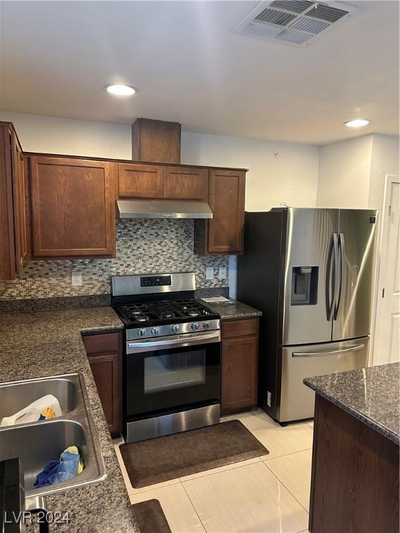 kitchen with appliances with stainless steel finishes, sink, backsplash, and range hood