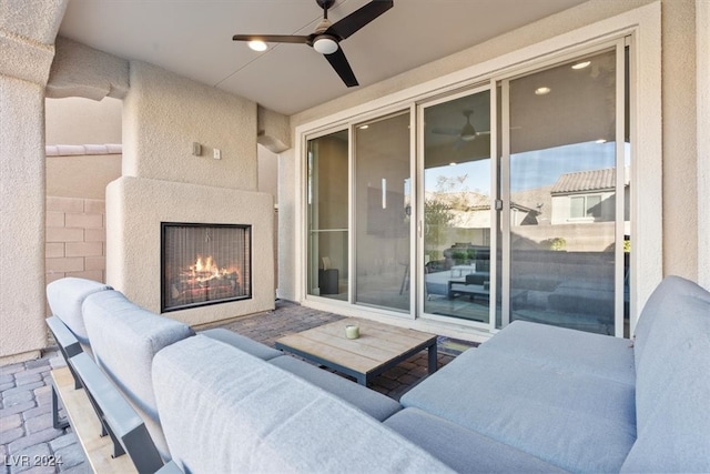 view of patio featuring an outdoor living space with a fireplace and ceiling fan