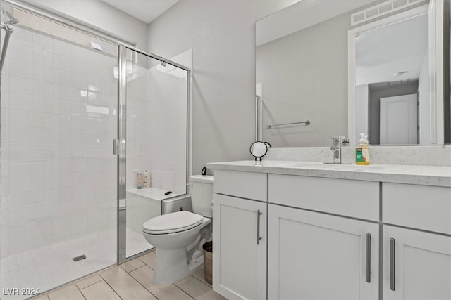 bathroom with vanity, toilet, and a shower with shower door