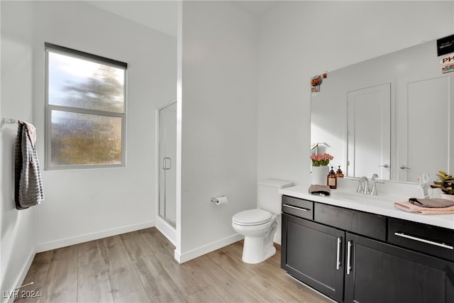 bathroom featuring hardwood / wood-style floors, vanity, an enclosed shower, and toilet