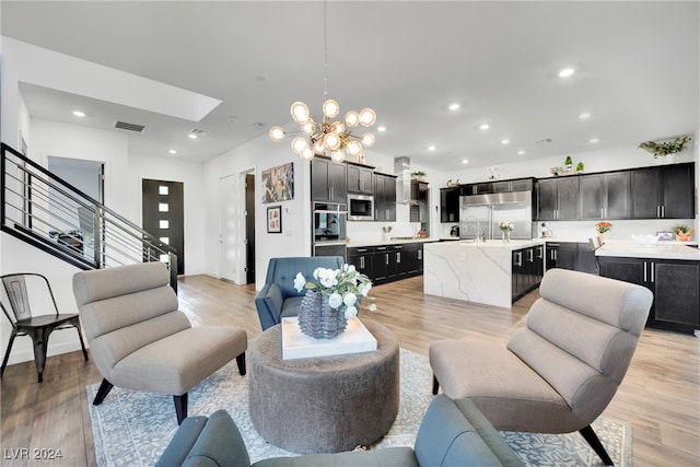 living room featuring light wood-type flooring and a chandelier