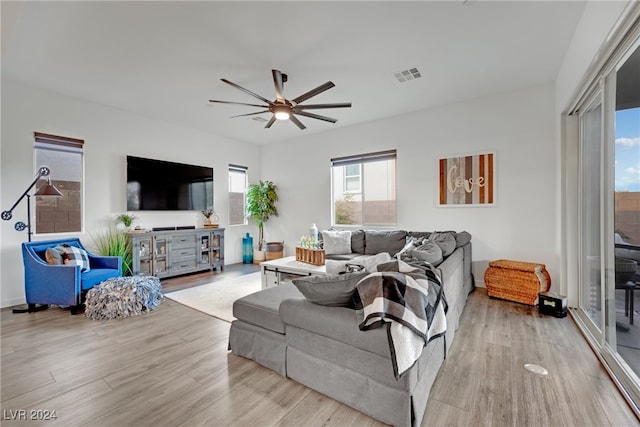 living room with light hardwood / wood-style floors and ceiling fan