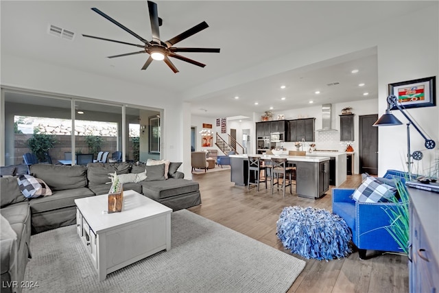 living room with ceiling fan and light hardwood / wood-style flooring