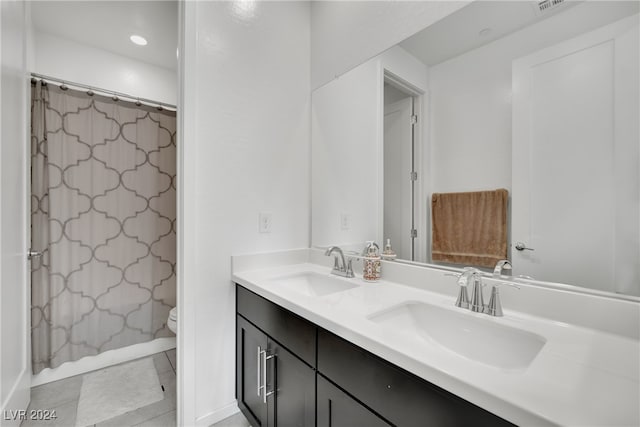 bathroom featuring toilet, vanity, tile patterned floors, and curtained shower