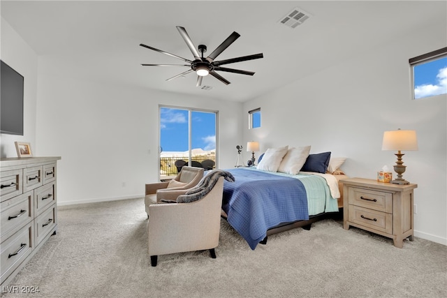 bedroom with multiple windows, light colored carpet, and ceiling fan