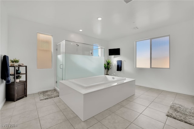 bathroom with tile patterned flooring and shower with separate bathtub