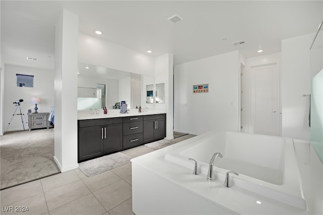 bathroom featuring a bathing tub, vanity, and tile patterned floors