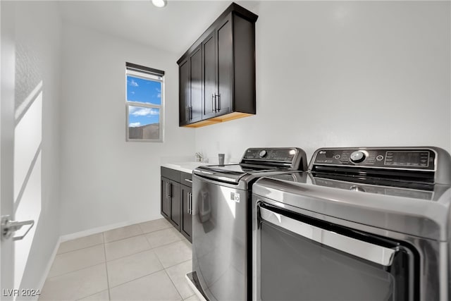 laundry area with cabinets, light tile patterned flooring, and washing machine and clothes dryer