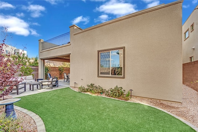 back of property featuring outdoor lounge area, a balcony, a yard, and a patio