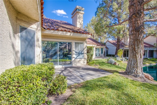 rear view of property featuring a yard and a patio area