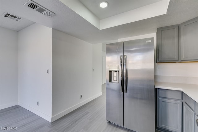 kitchen featuring gray cabinets, stainless steel fridge, and light hardwood / wood-style flooring