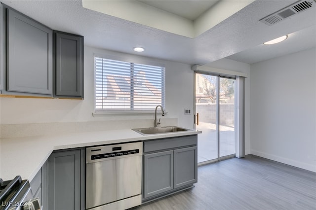 kitchen with sink, appliances with stainless steel finishes, gray cabinetry, a textured ceiling, and light wood-type flooring