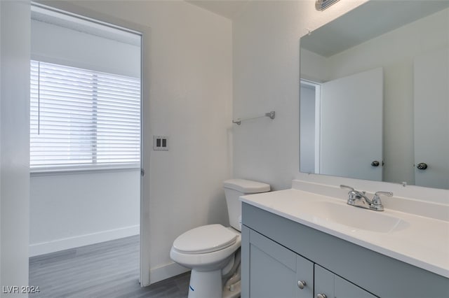 bathroom featuring vanity, hardwood / wood-style floors, and toilet