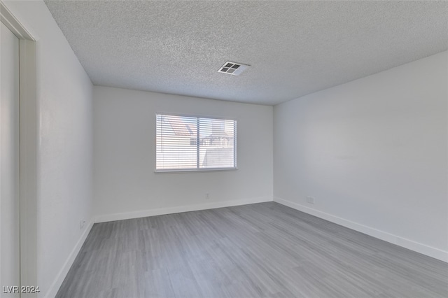 empty room featuring a textured ceiling and light wood-type flooring