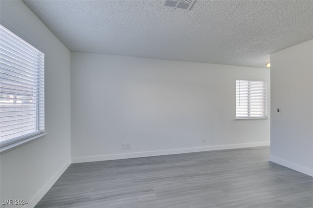 spare room with hardwood / wood-style flooring and a textured ceiling